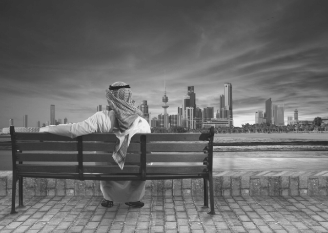 Man sitting on a bench and looking at Kuwait city